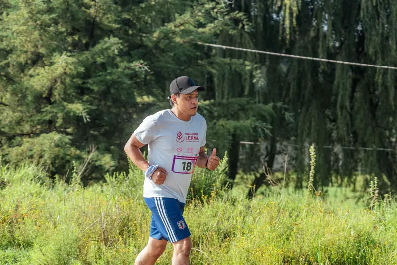 A man running along a trail through a green forest